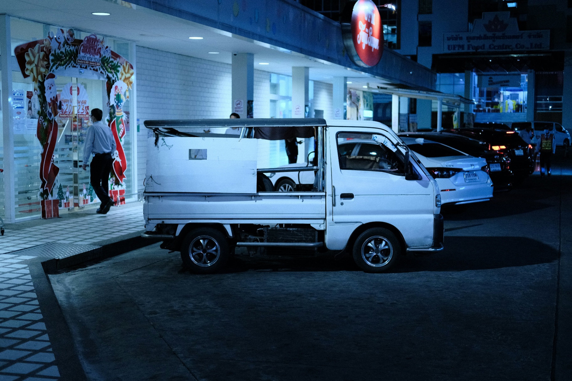 White Kei truck parked outside a shop at night in Japan
