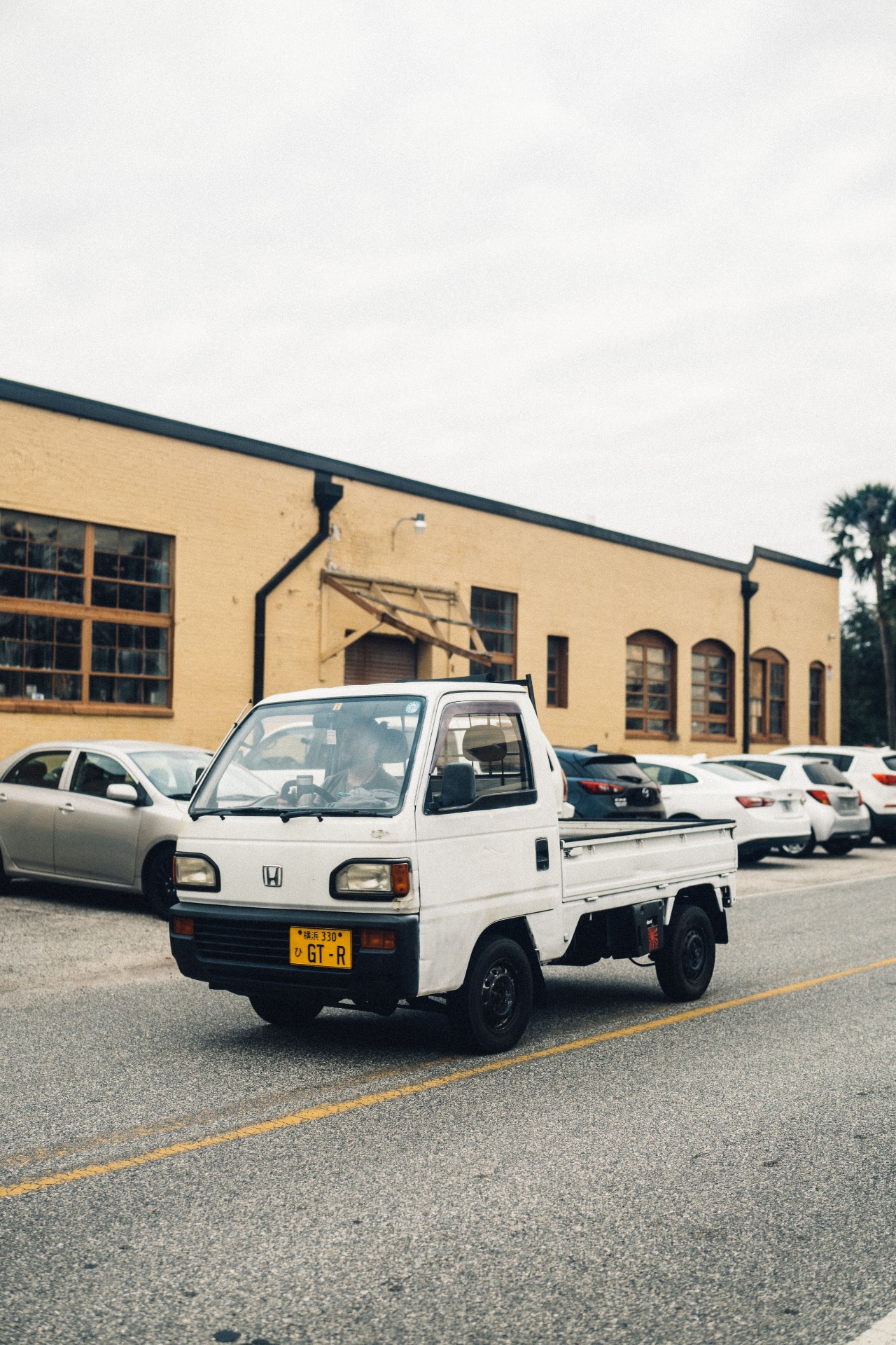 White Honda Acty Kei truck driving down a street