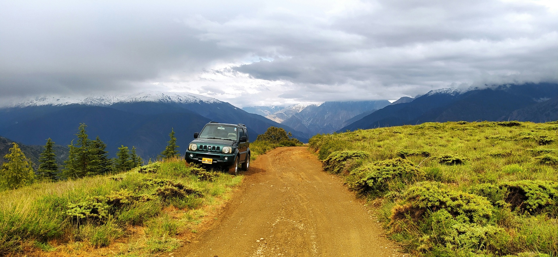 Green Suzuki Jimny on a mountain dirt road in Japan