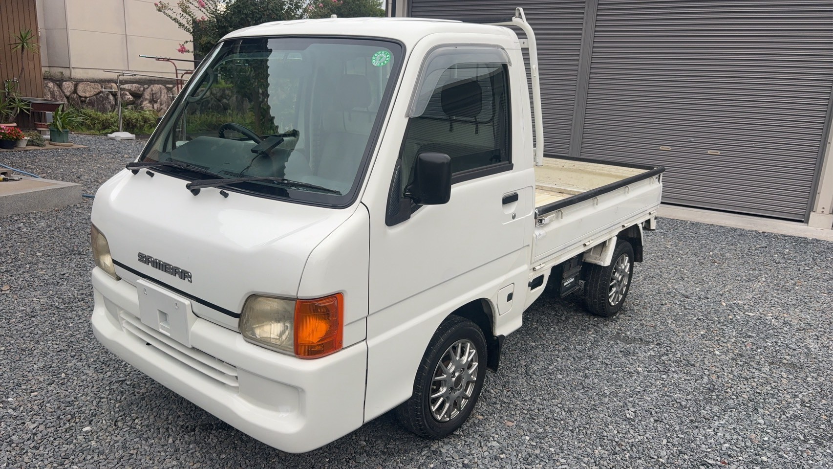 White 2000 Subaru Sambar kei truck with new wheels, front left view, right-hand drive, flatbed