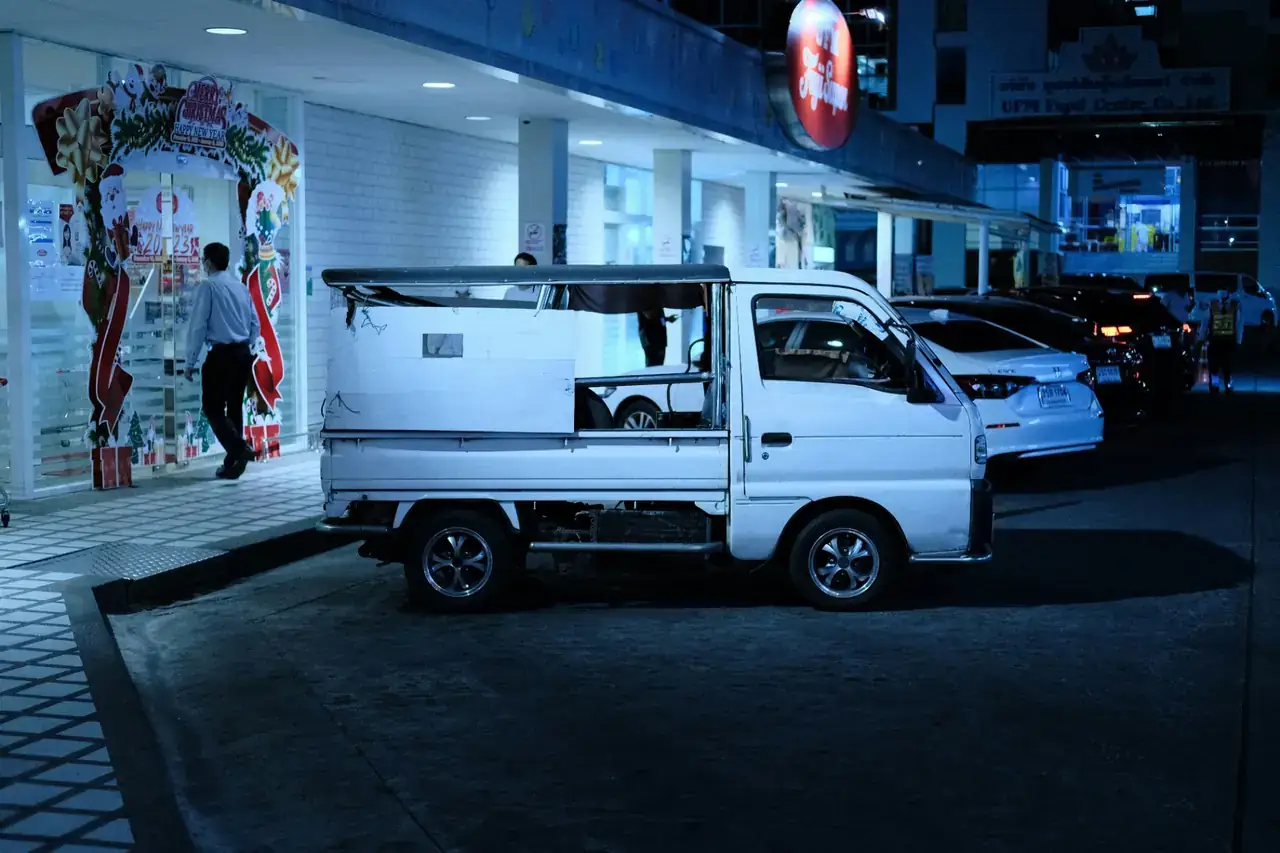 White Kei truck parked outside a shop at night in Japan